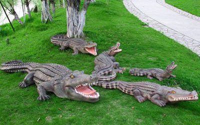 公園草地上擺放的形態(tài)各異的玻璃鋼仿真動(dòng)物鱷魚雕塑